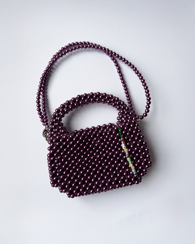 Purple Oval Bag made of shimmering purple pearl-acrylic beads, shown with structured short handle and wide adjustable strap. Handcrafted in Lisbon.