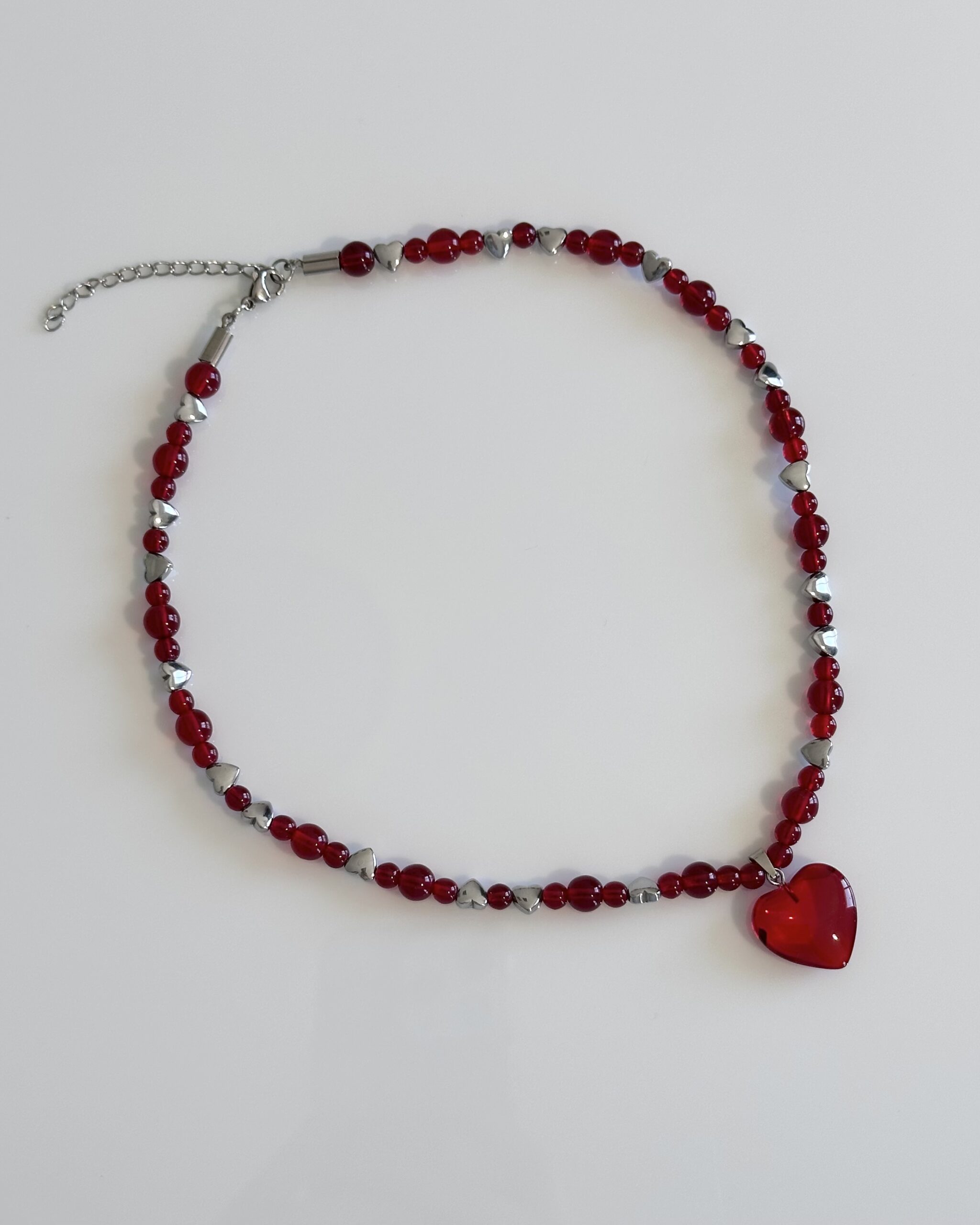 Red glass beaded necklace with silver hematite hearts and a red heart pendant on an adjustable stainless steel closure, handmade by NIICA in Lisbon